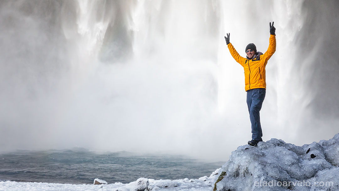Standing on ice by the water's edge at Skogafoss.
