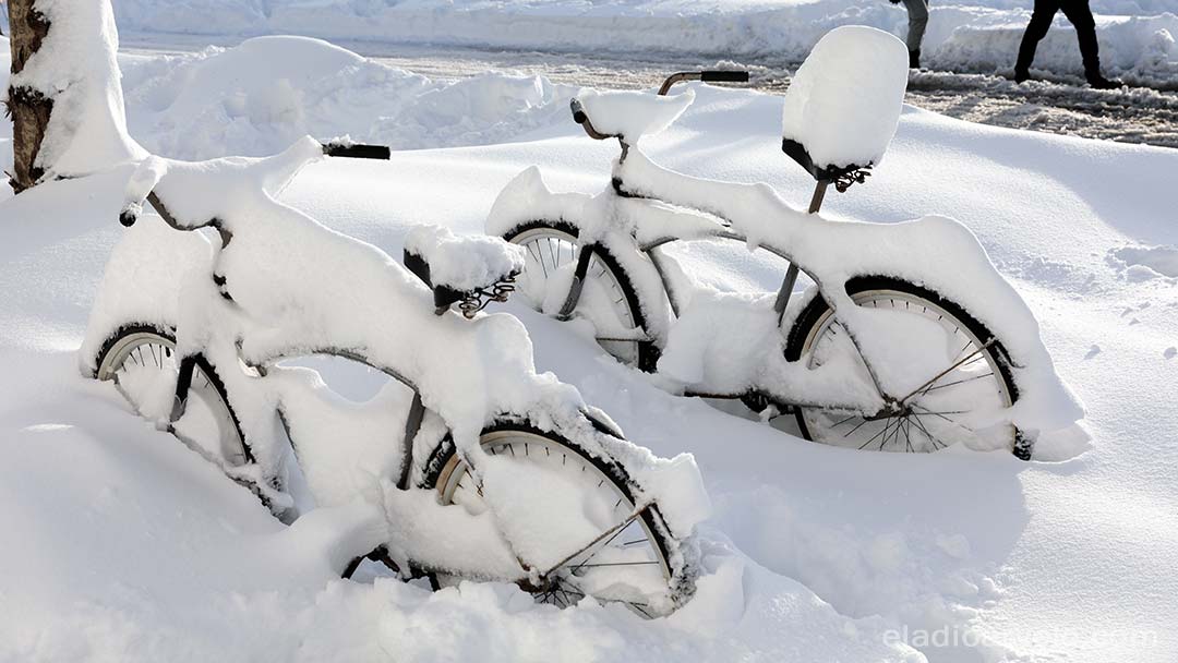 Bicycles covered in snow.