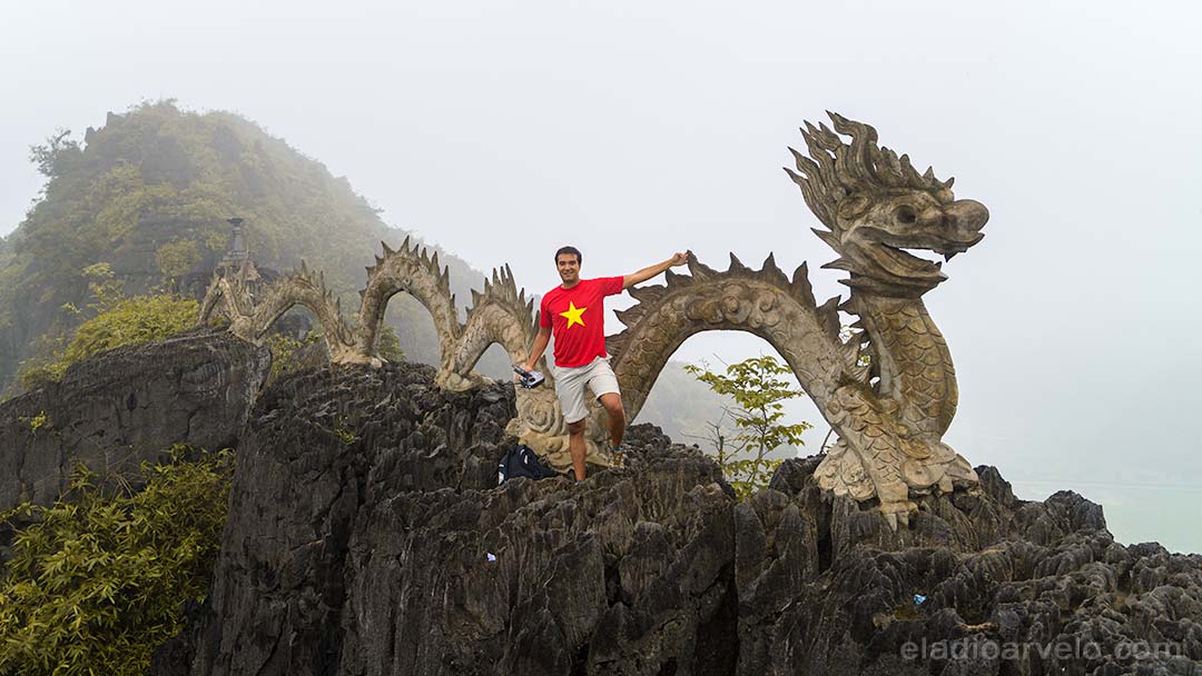 Eladio standing next to the stone carved dragon atop Hang Mua Peak in Ninh Binh.
